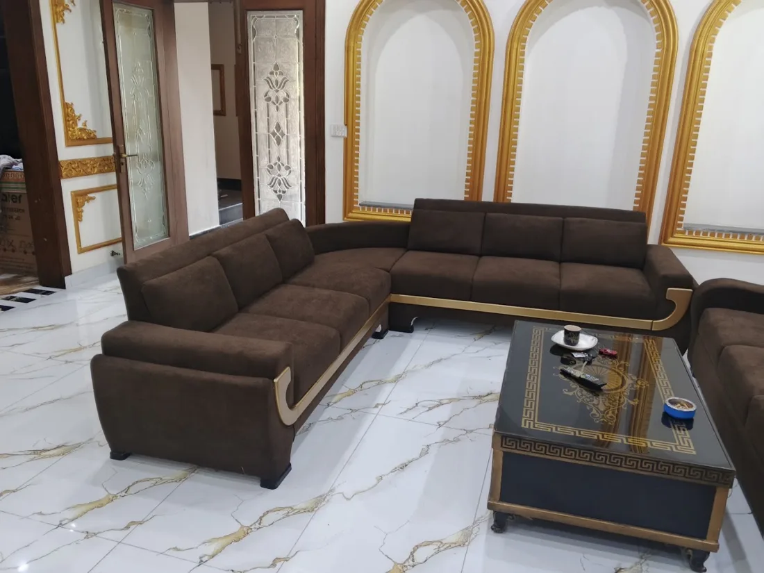 Dark brown L-shaped sofa with gold trim, reupholstered