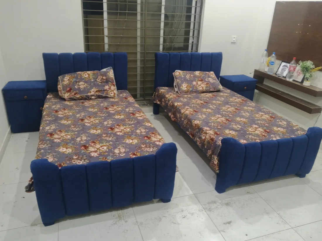 Two navy single beds with channel headboards