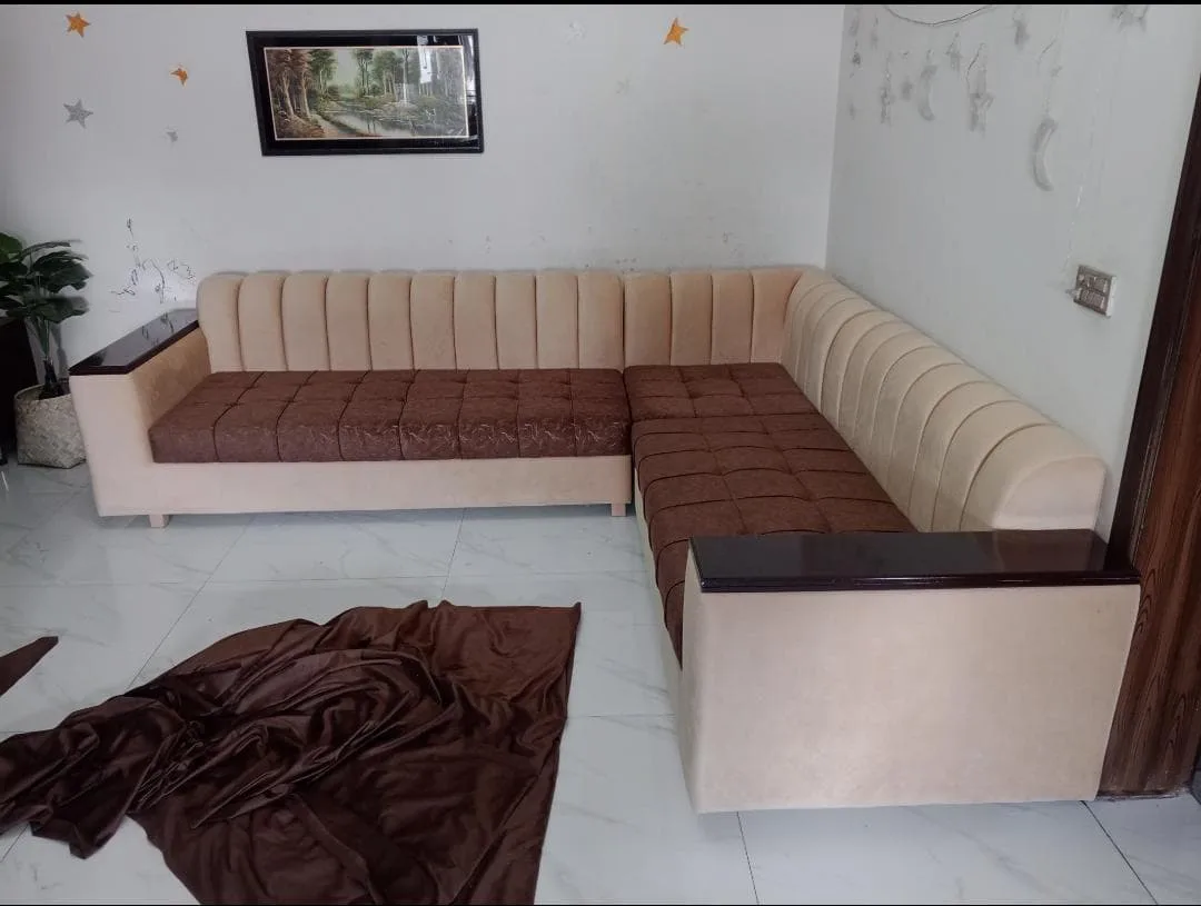 A peach channel-tufted L-shaped sofa just finished by Ahmad Shakir, the new fabric still on the floor